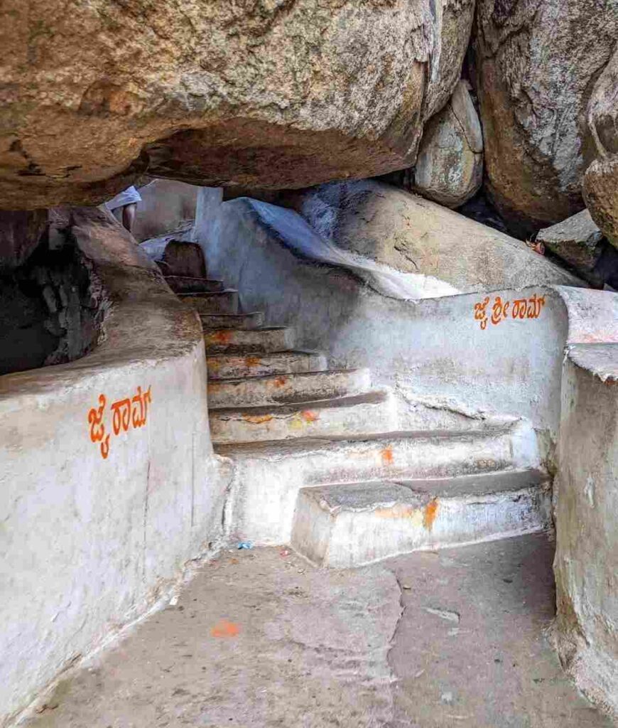 A pathway of steps leading from under a large boulder