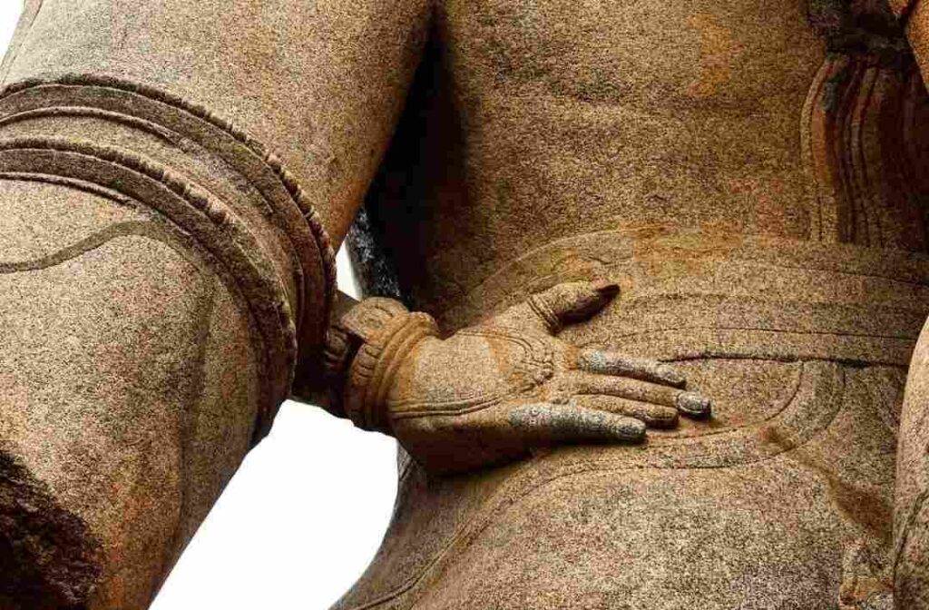 Lakshmi's hand. See nails and rings on her fingers