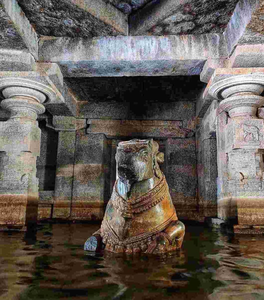Nandi sits majestically in front of the sanctum sanctorum and water is surrounding