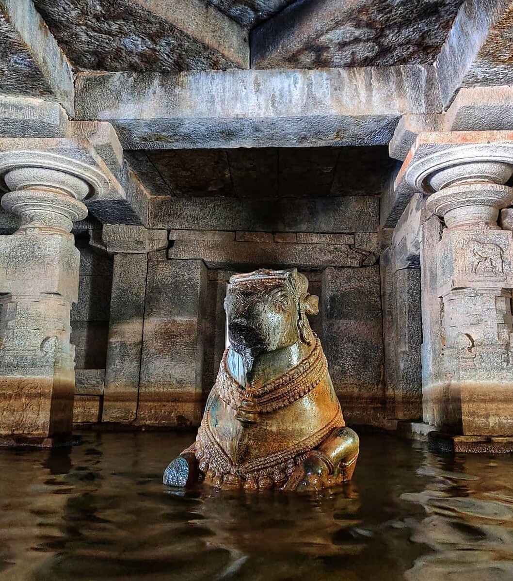 Nandi sits majestically in front of the sanctum sanctorum and water is surrounding