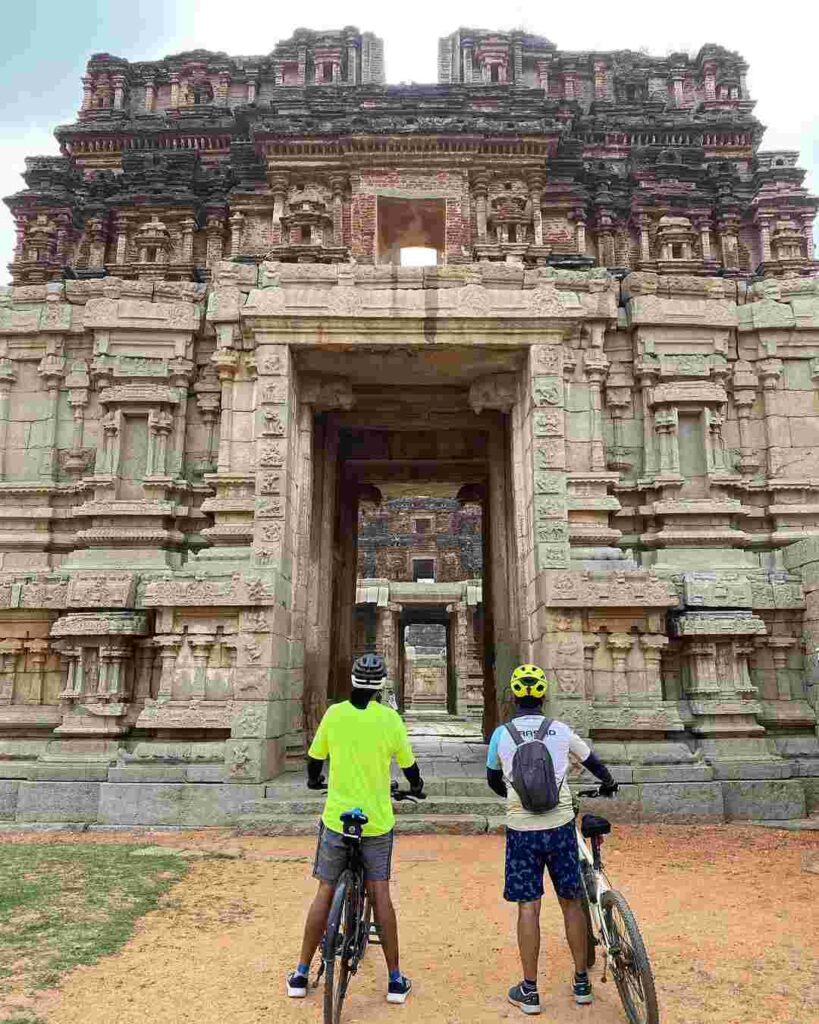 Young people exploring Hampi's ruins by bicycle